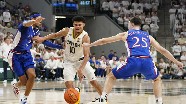 Mar 2, 2024; Waco, Texas, USA; Baylor Bears guard RayJ Dennis (10) splits the defense of Kansas Jayhawks guard Dajuan Harris Jr. (3) and guard Nicolas Timberlake (25) during the second half at Paul and Alejandra Foster Pavilion.