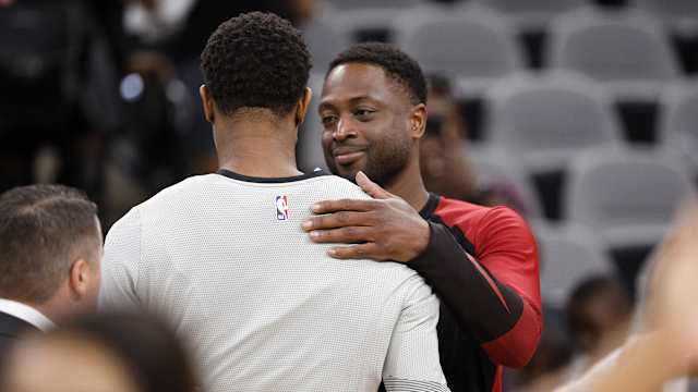 Miami Heat shooting guard Dwyane Wade (behind) hugs San Antonio Spurs shooting guard DeMar DeRozan (front)