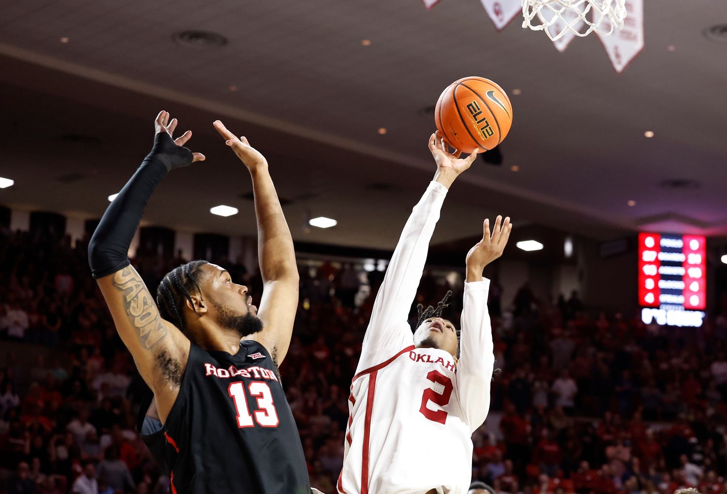 Mar 2, 2024; Norman, Oklahoma, USA; Oklahoma Sooners guard Javian McCollum (2) shoots beside Houston Cougars forward J'Wan Roberts (13) during the second half at Lloyd Noble Center. Mandatory Credit: Alonzo Adams-USA TODAY Sports