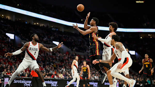 Mar 13, 2024; Portland, Oregon, USA; Atlanta Hawks forward De'Andre Hunter (12) passes the ball during the second half against Portland Trail Blazers guard Matisse Thybulle (4) and center Deandre Ayton (2) at Moda Center. Mandatory Credit: Troy Wayrynen-USA TODAY Sports