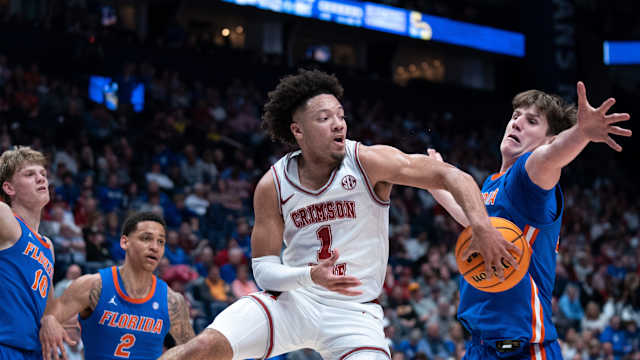 Alabama Crimson Tide guard Mark Sears (1) makes a no-look pass beneath Florida Gators forward Alex Condon (21) during their SEC Men's Basketball Tournament quarterfinal game at Bridgestone Arena in Nashville, Tenn., Friday, March 15, 2024.at Bridgestone Arena in Nashville, Tenn., Friday, March 15, 2024.