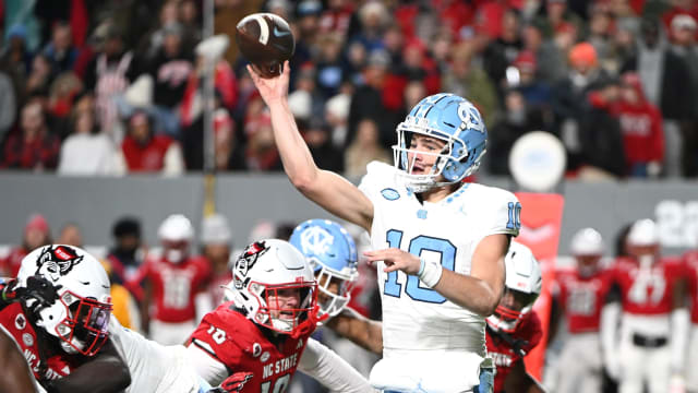 Nov 25, 2023; Raleigh, North Carolina, USA; North Carolina Tar Heels quarterback Drake Maye (10) throws a pass against North Carolina State Wolfpack linebacker Caden Fordham during the first half at Carter-Finley Stadium.
