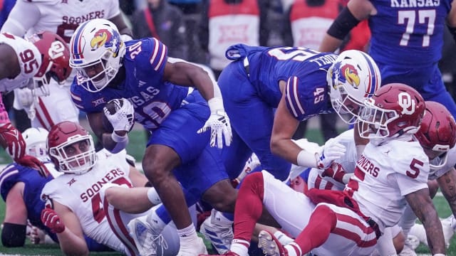 Oct 28, 2023; Lawrence, Kansas, USA; Kansas Jayhawks running back Daniel Hishaw Jr. (20) scores as Oklahoma Sooners defensive lineman Ethan Downs (40) and defensive back Woodi Washington (5) look on during the second half at David Booth Kansas Memorial Stadium. 