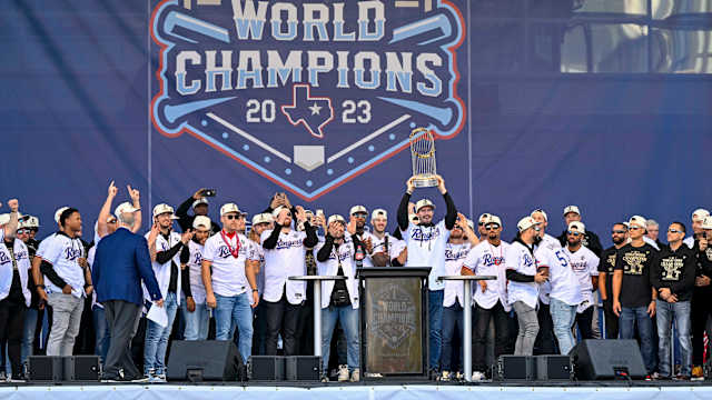 Texas Rangers starting pitcher Andrew Heaney raises the trophy during the celebration outside of the ballpark after the World Series championship parade at Globe Life Field.