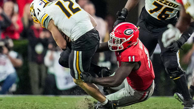 Missouri Tigers quarterback Brady Cook (12) is sacked by Georgia Bulldogs linebacker Jalon Walker (11) during the second half at Sanford Stadium