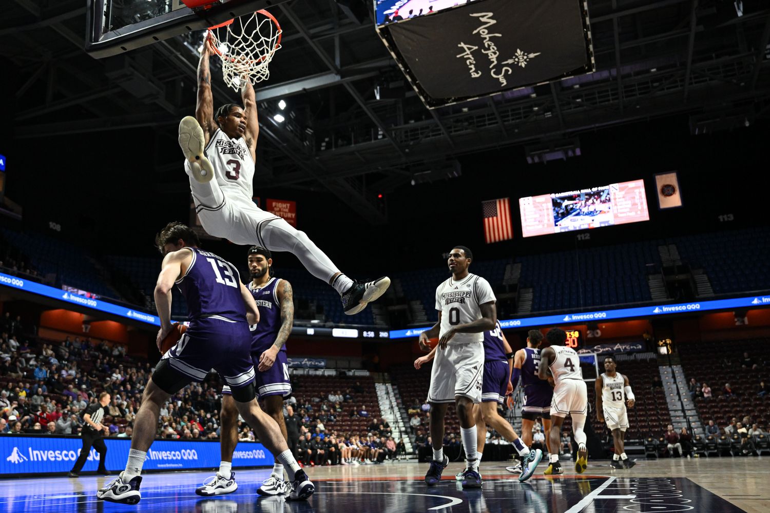 Nov 19, 2023; Uncasville, CT, USA; Mississippi State Bulldogs guard Shakeel Moore (3) hangs on the rim after Dunkin g the ball over Northwestern Wildcats guard Brooks Barnhizer (13) while Mississippi State Bulldogs forward D.J. Jeffries (0) looks on during the second half at Mohegan Sun Arena. Mandatory Credit: Mark Smith-USA TODAY Sports
