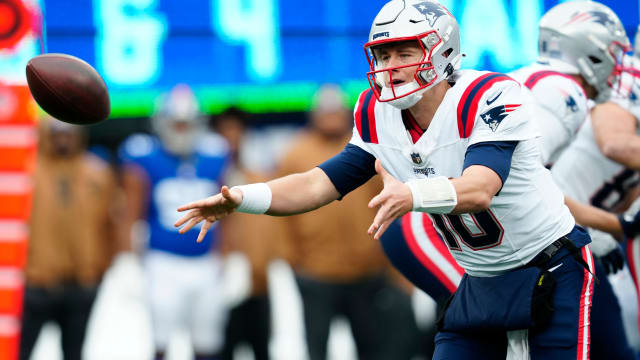 New England Patriots QB Mac Jones attempts a toss to a teammate against the New York Giants in Week 12; 26 Nov. 2023
