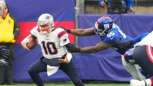 New York Giants linebacker Jihad Ward (55) has a hold on New England Patriots quarterback Mac Jones (10) in the 1st half at MetLife Stadium.