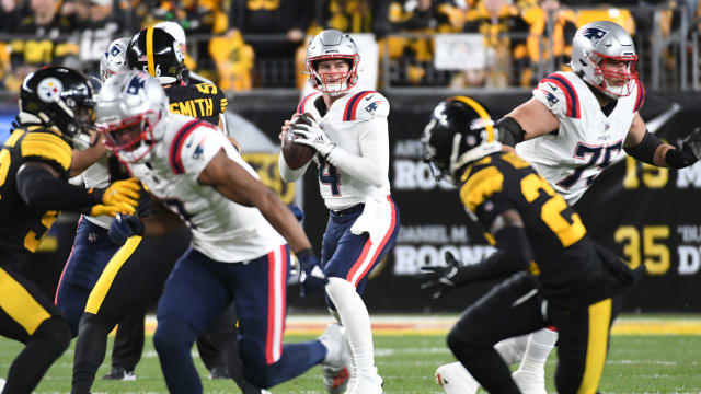 New England Patriots quarterback Bailey Zappe (4) looks for a receiver against the Pittsburgh Steelers during the first quarter at Acrisure Stadium.
