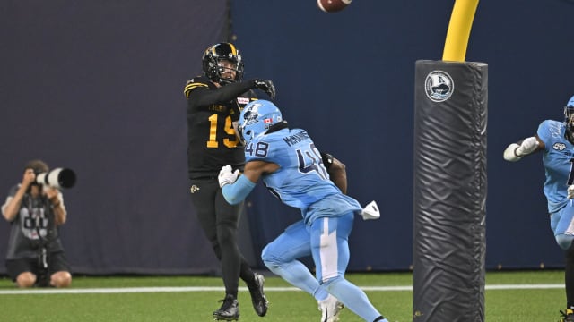 Jun 18, 2023; Toronto, Ontario, CAN; Hamilton Tiger-Cats quarterback Bo Levi Mitchell (19) throws the ball under pressure from Toronto Argonauts linebacker Wynton McManis (48) in the fourth quarter at BMO Field. Mandatory Credit: Dan Hamilton-USA TODAY Sports
