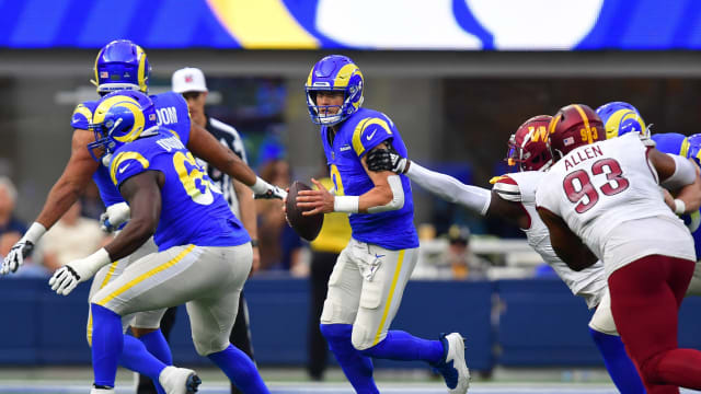 Los Angeles Rams quarterback Matthew Stafford (9) moves out to pass against the Washington Commanders during the first half at SoFi Stadium.