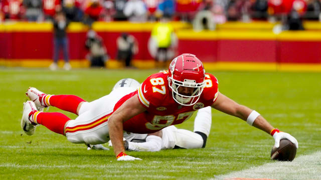 Dec 25, 2023; Kansas City, Missouri, USA; Kansas City Chiefs tight end Travis Kelce (87) dives for the sideline against Las Vegas Raiders cornerback Nate Hobbs (39) during the first half at GEHA Field at Arrowhead Stadium. Mandatory Credit: Jay Biggerstaff-USA TODAY Sports  