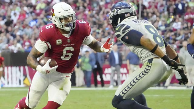 Arizona Cardinals running back James Conner (6) runs against Seattle Seahawks cornerback Coby Bryant (8) during the fourth quarter at State Farm Stadium.