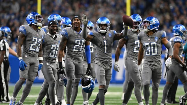 Detroit Lions defensive backs celebrate Cam Sutton's interception against the Minnesota Vikings.