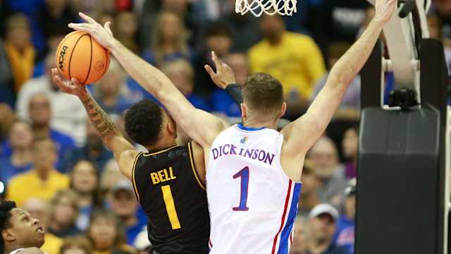 Kansas senior center Hunter Dickinson (1) blocks a shot by Wichita State junior guard Xavier Bell (1) during the first half of Saturday's game inside T-Mobile Center in Kansas City.  