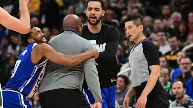 Sacramento Kings head coach Mike Brown is restrained by guard Malik Monk (0) as he argues with referee Intae Hwang i