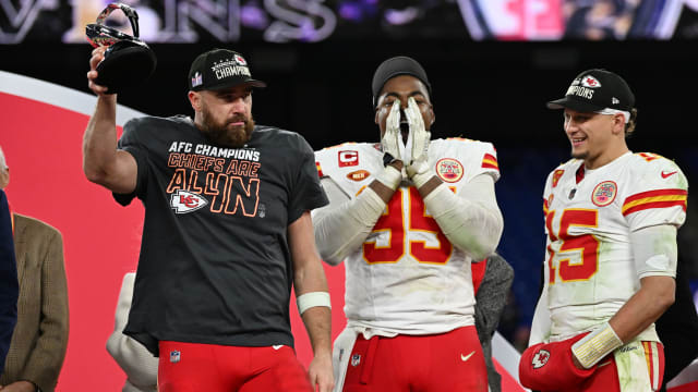 Travis Kelce raises a trophy next to Chris Jones and Patrick Mahomes