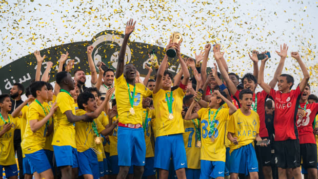 Cristiano Jr, the eldest son of Cristiano Ronaldo, pictured lifting the Saudi U13 Premier League trophy in March 2024 with his teammates while wearing a captain's armband