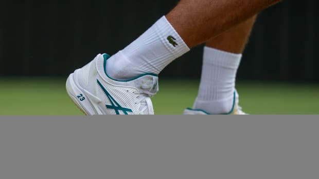 Novak Djokovic's white and green Lacoste tennis shoes.