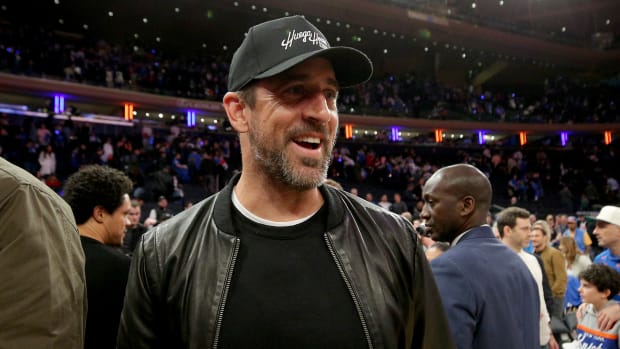 Aaron Rodgers walks off the court after a Knicks game.