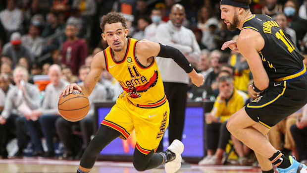 Hawks guard Trae Young dribbles past Warriors guard Klay Thompson.