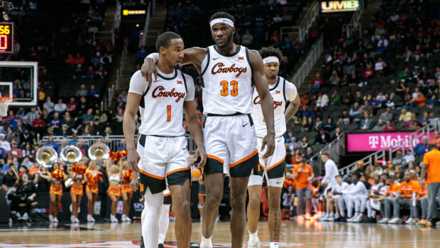 Mar 8, 2023; Kansas City, MO, USA; Oklahoma State Cowboys guard Bryce Thompson (1) and Oklahoma State Cowboys forward Moussa Cisse (33) walk on the court during a break in play during the second half against the Oklahoma Sooners at T-Mobile Center. Mandatory Credit: William Purnell-USA TODAY Sports