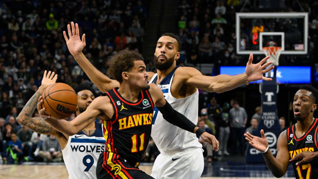 Atlanta Hawks guard Trae Young makes a pass around Minnesota Timberwolves center Rudy Gobert.