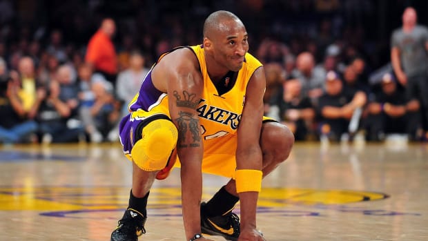 Los Angeles Lakers shooting guard Kobe Bryant squats down during a game.