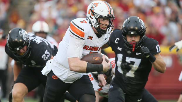 Oklahoma State Cowboys quarterback Alan Bowman (7) runs with the ball for a touchdown around Iowa State Cyclones defensive back Beau Freyler (17) and defensive back Trevon Howard (25)during the first quarter of an NCAA college football game at Jack Trice Stadium on Saturday, Sept. 23, 2023, in Ames, Iowa.