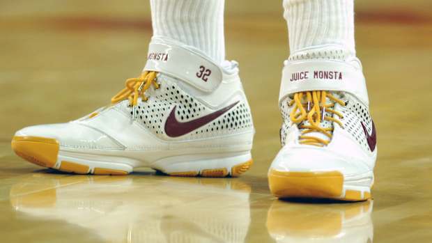 View of white and gold Nike Kobe shoes.