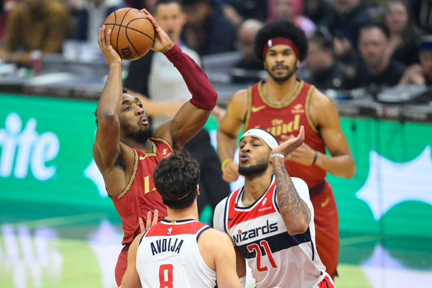 Jan 3, 2024; Cleveland, Ohio, USA; Cleveland Cavaliers guard Donovan Mitchell (45) shoots between Washington Wizards forward Deni Avdija (8) and center Daniel Gafford (21) in the first quarter at Rocket Mortgage FieldHouse. Mandatory Credit: David Richard-USA TODAY Sports