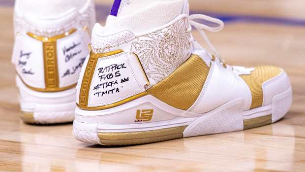 View of LeBron James' white and gold Nike shoes.