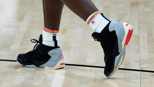 View of black, grey, and red Jordan Zion shoes.