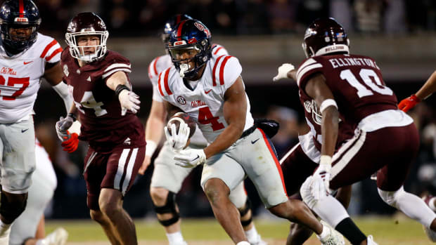 Nov 23, 2023; Starkville, Mississippi, USA; Mississippi Rebels running back Quinshon Judkins (4) runs the ball as Mississippi State Bulldogs linebacker Jett Johnson (44) and defensive back Corey Ellington (10) attempt to make the tackle during the second half at Davis Wade Stadium at Scott Field. Mandatory Credit: Petre Thomas-USA TODAY Sports