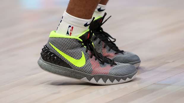 Grey and green Nike Kyrie shoes.