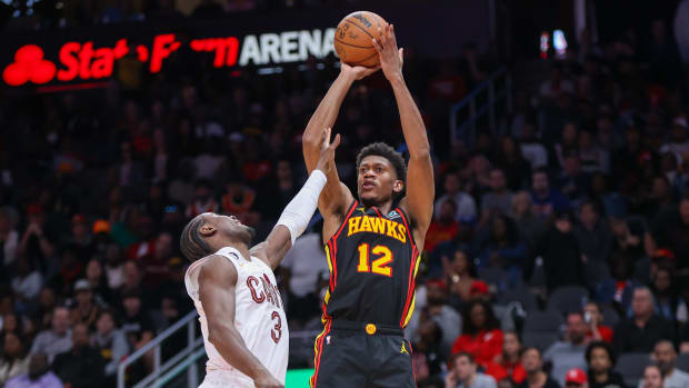 Mar 28, 2023; Atlanta, Georgia, USA; Atlanta Hawks forward De'Andre Hunter (12) shoots over Cleveland Cavaliers guard Caris LeVert (3) in the second half at State Farm Arena. Mandatory Credit: Brett Davis-USA TODAY Sports