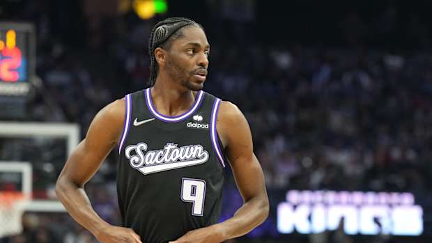 Justin Holiday tucks in his black Sacramento Kings jersey.
