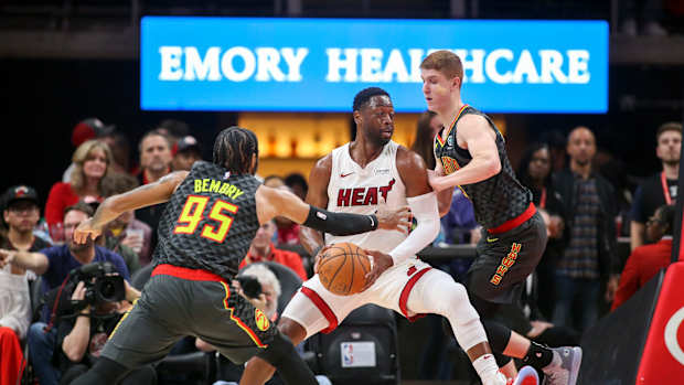 Atlanta Hawks forward DeAndre' Bembry (95) and guard Kevin Huerter (3) defend Miami Heat guard Dwyane Wade.