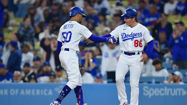 Sep 19, 2023; Los Angeles, California, USA; Los Angeles Dodgers second baseman Mookie Betts (50) is greeted by first base coach Clayton McCullough (86) after hitting a single against the Detroit Tigers during the seventh inning at Dodger Stadium.