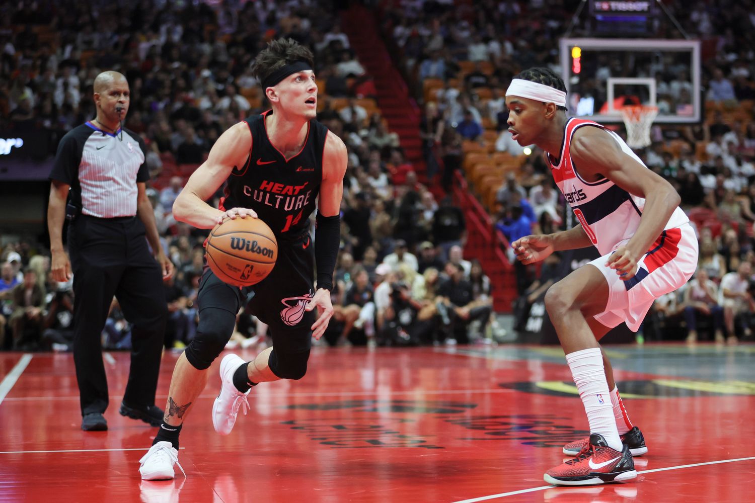 Miami Heat guard Tyler Herro (14) dribbles the basketball as Washington Wizards guard Bilal Coulibaly (0) defends during the fourth quarter at Kaseya Center. Mandatory Credit: Sam Navarro-USA TODAY Sports
