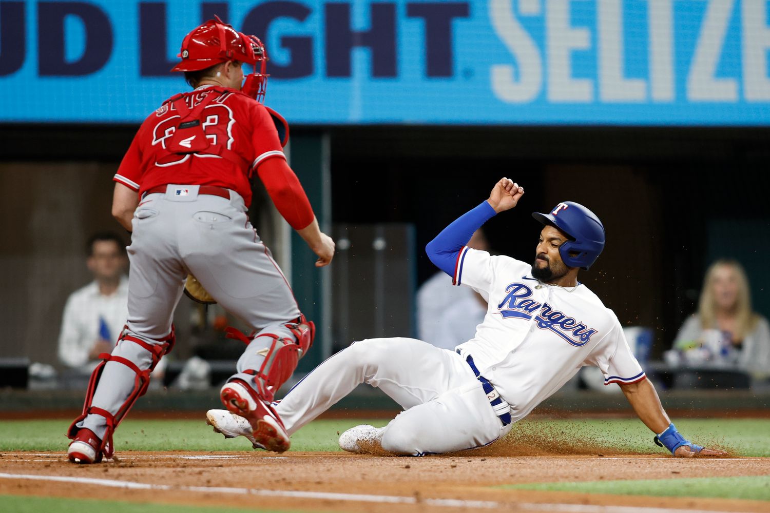Sep 20, 2022; Arlington, Texas, USA; Texas Rangers second baseman Marcus Semien (2) slides into home plate to score a run as Los Angeles Angels catcher Max Stassi (33) waits for the throw at Globe Life Field. Mandatory Credit: Tim Heitman-USA TODAY Sports