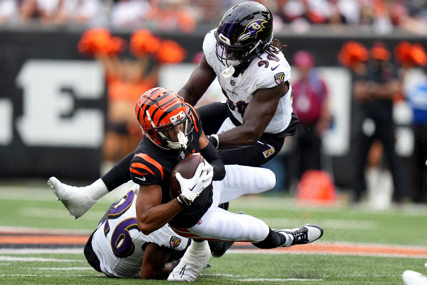 Cincinnati Bengals wide receiver Tyler Boyd (83) is tackled after a catch by Baltimore Ravens safety Geno Stone (26) and linebacker David Ojabo (90).