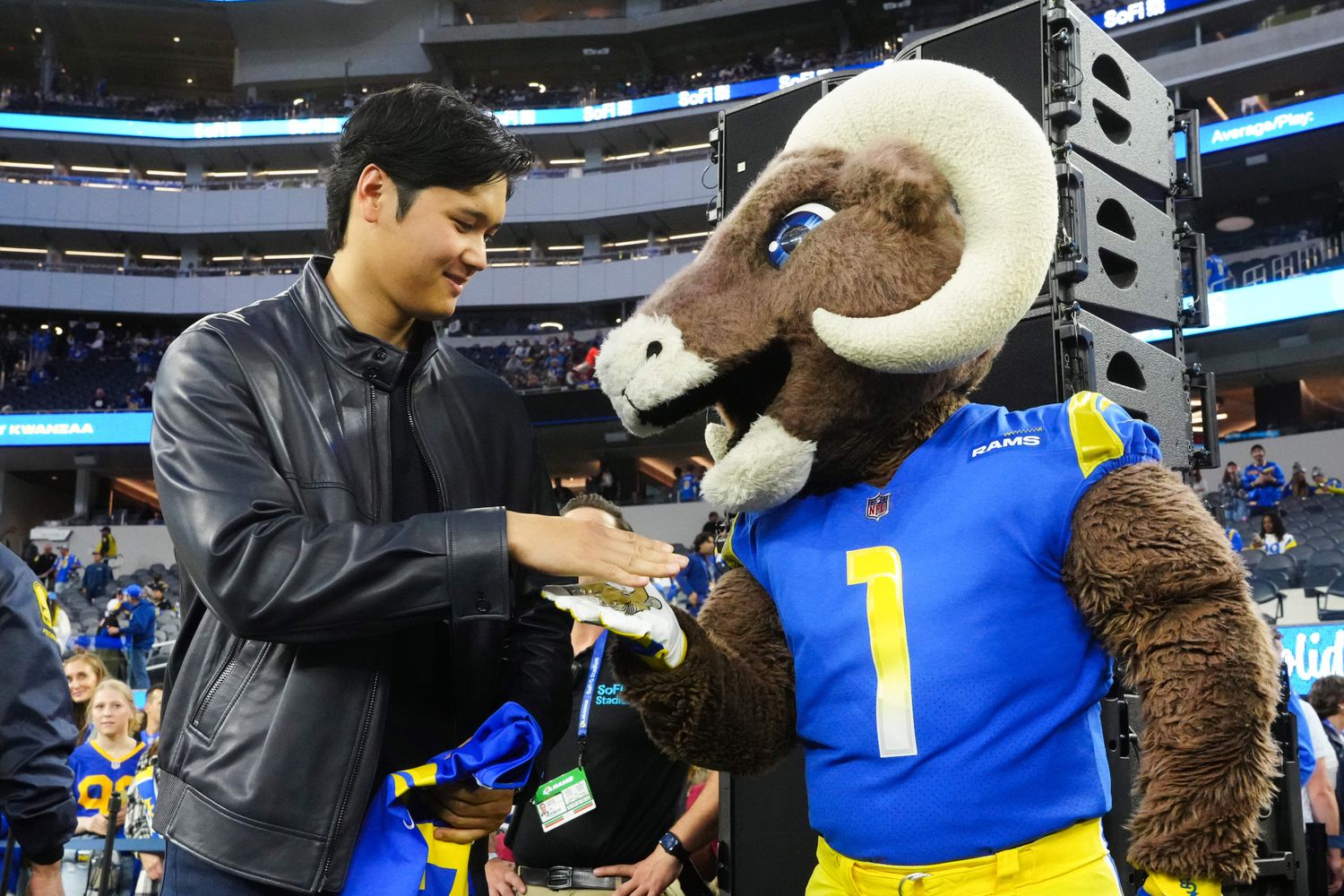 Los Angeles Dodgers player Shohei Ohtani shakes hands with the Los Angeles Rams mascot.