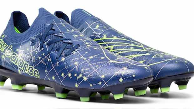 Side view of blue and green New Balance soccer cleats.