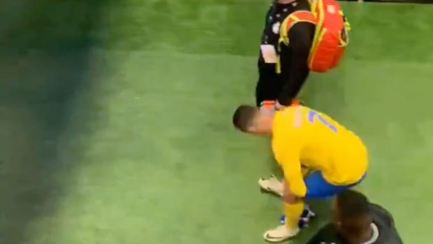 Cristiano Ronaldo pictured (center) bending down to pick up an Al-Hilal scarf before rubbing it against his crotch following his Al Nassr team's 2-0 defeat in the final game of the 2024 Riyadh Season Cup