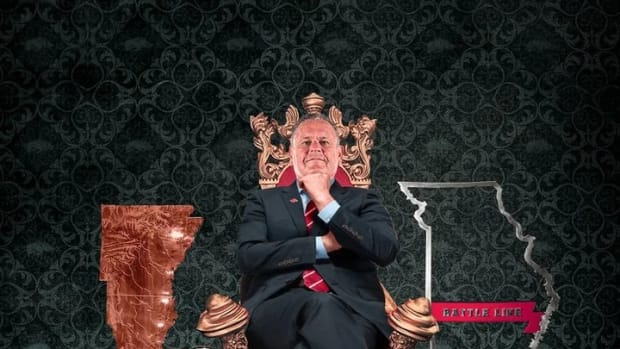 Sam Pittman sits on a throne surrounded by all the trophies his Razorbacks won in 2021, along with Larry the Bowling Ball.