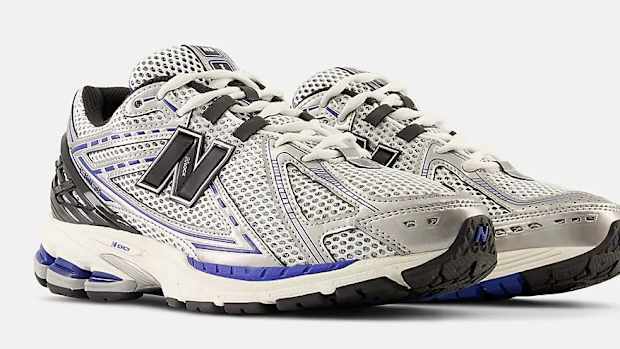 Side view of silver and black New Balance shoes.