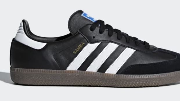 Side view of a black and white adidas shoe.
