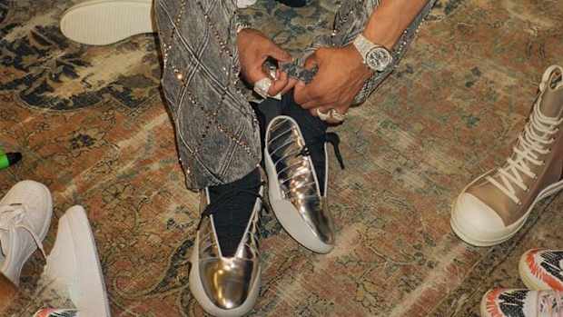 Lil Baby tries on shoes.
