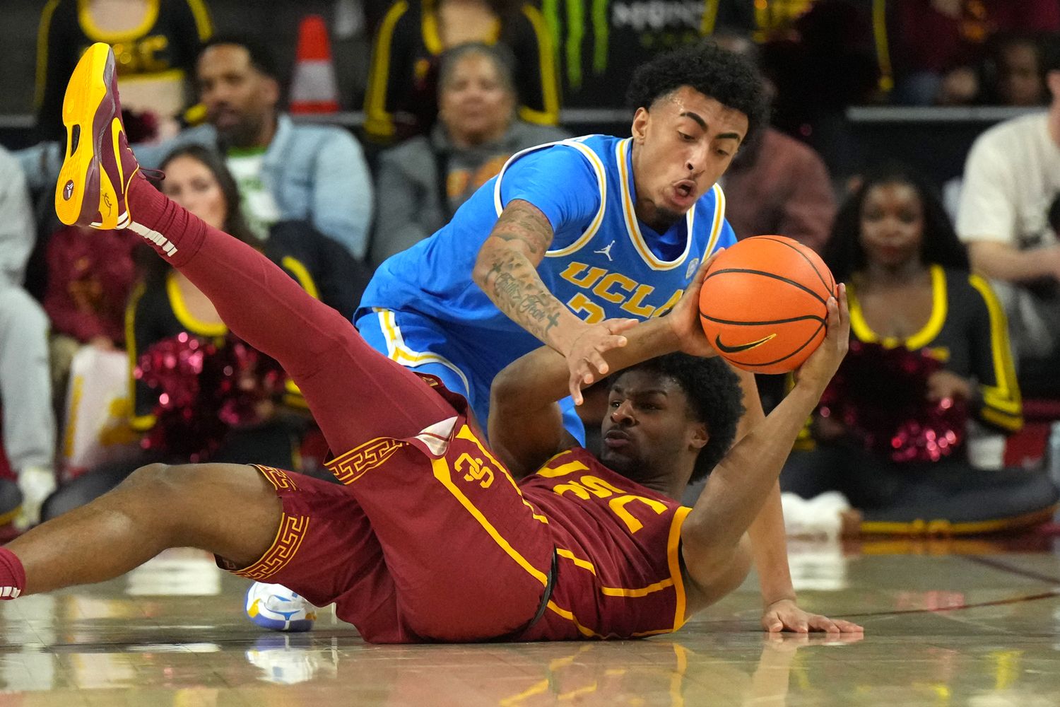 USC Trojans guard Bronny James and UCLA Bruins forward Devin Williams battle for a loose ball.